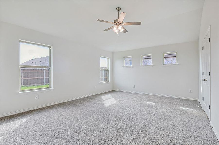 Carpeted spare room with ceiling fan