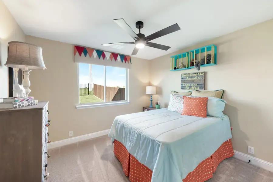 Children's bedroom with ceiling fan, full bed, carpet flooring, and a window with colorful pennant banner valance Children's bedroom with ceiling fan, full bed, carpet flooring, and a window with colorful pennant banner valance
