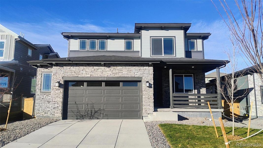 Front exterior of a new home in The Cottages Collection at Ridgeline Vista, Brighton, CO, highlighting curb appeal (Image 1).