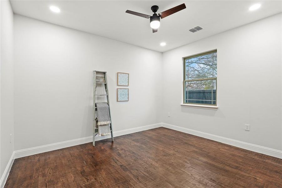 Empty room with a ceiling fan, dark wood-style floors, and recessed lighting