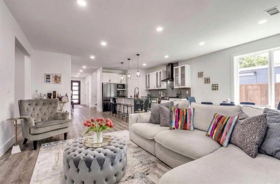 Living area with light wood finished floors, plenty of natural light, and recessed lighting