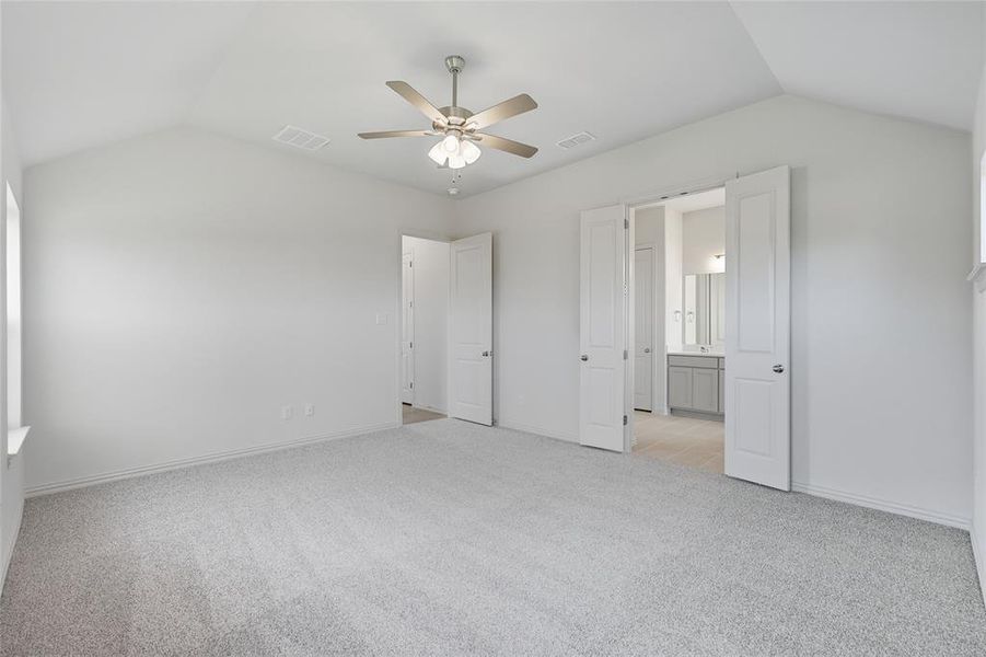 Unfurnished bedroom with lofted ceiling, light colored carpet, and a ceiling fan Unfurnished bedroom with lofted ceiling, light colored carpet, and a ceiling fan