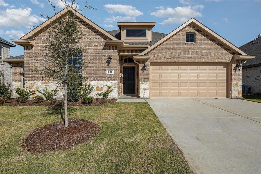 View of front of home featuring a front yard and a garage