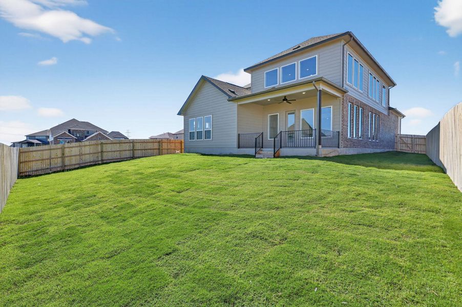 Rear view of property with a ceiling fan, a fenced backyard, and a patio