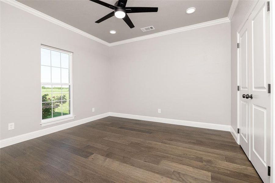 Empty room with crown molding, visible vents, baseboards, and a ceiling fan Empty room with crown molding, visible vents, baseboards, and a ceiling fan