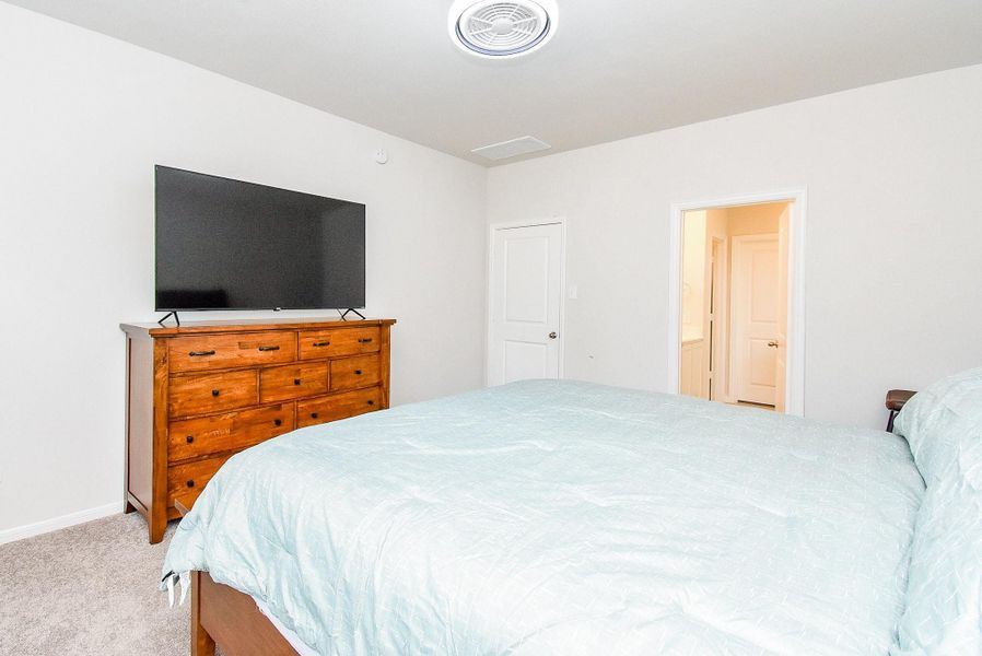 The primary bedroom features clean, like-new carpet and an elegant chandelier. The primary bedroom features clean, like-new carpet and an elegant chandelier.