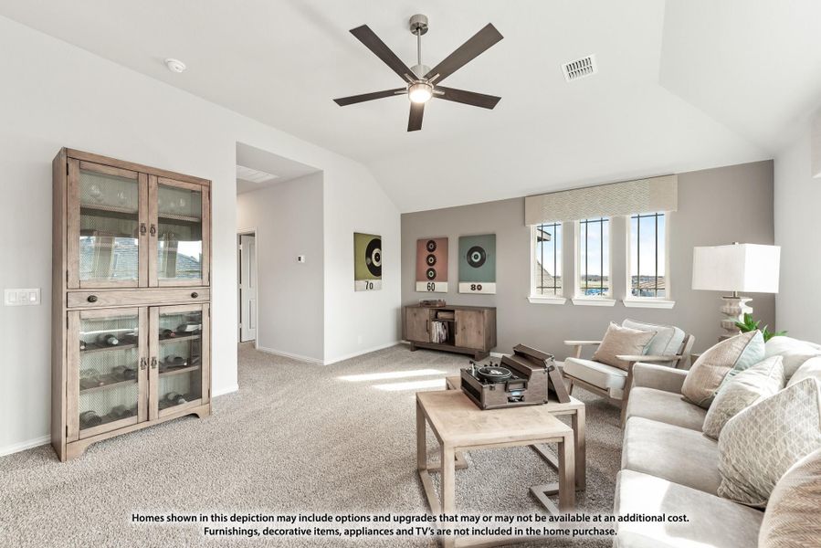 Living room with vaulted ceiling, ceiling fan, carpet flooring, and neutral furniture including sofa and wood cabinet. Living room with vaulted ceiling, ceiling fan, carpet flooring, and neutral furniture including sofa and wood cabinet.