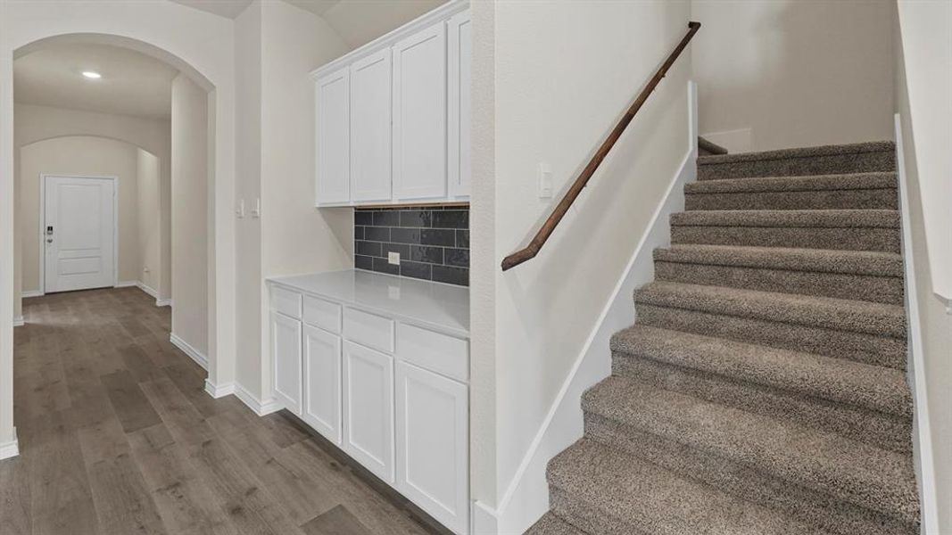 Stairs featuring arched walkways and wood finished floors Stairs featuring arched walkways and wood finished floors