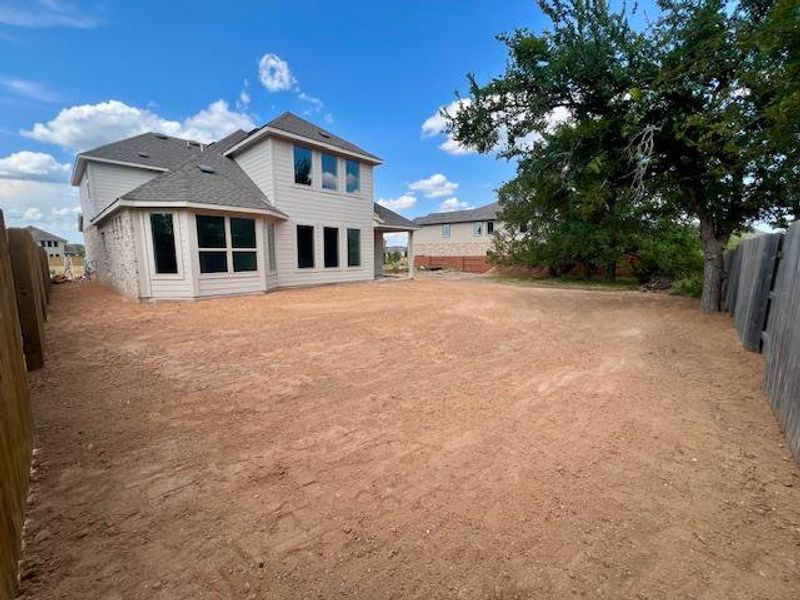 Back of property featuring a fenced backyard and a shingled roof Back of property featuring a fenced backyard and a shingled roof