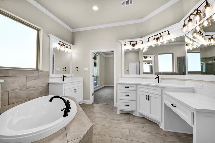 Bathroom with vanity, crown molding, tiled tub, and tile patterned floors