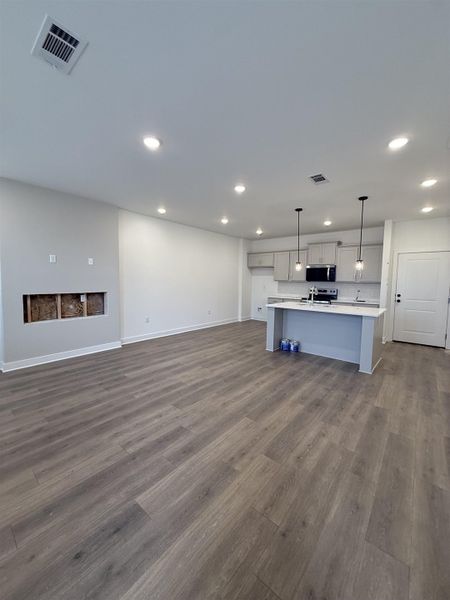 Unfurnished living room with dark wood finished floors and recessed lighting