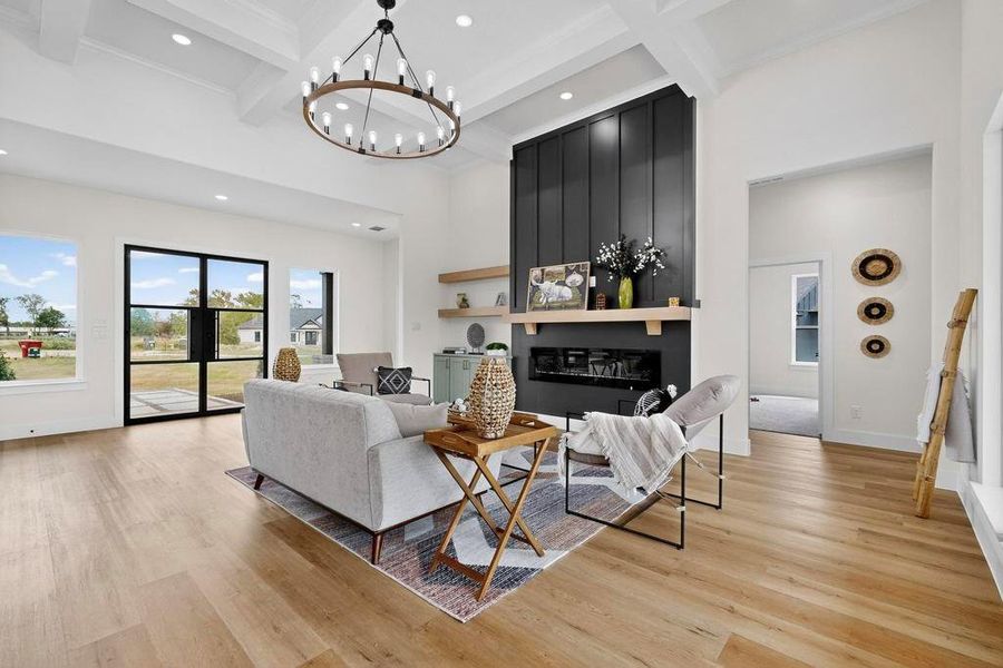 Living room featuring recessed lighting, beam ceiling, coffered ceiling, a high ceiling, and light wood-style flooring Living room featuring recessed lighting, beam ceiling, coffered ceiling, a high ceiling, and light wood-style flooring