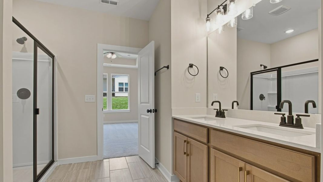 En-suite primary bathroom with dual sink vanity and walk-in shower En-suite primary bathroom with dual sink vanity and walk-in shower