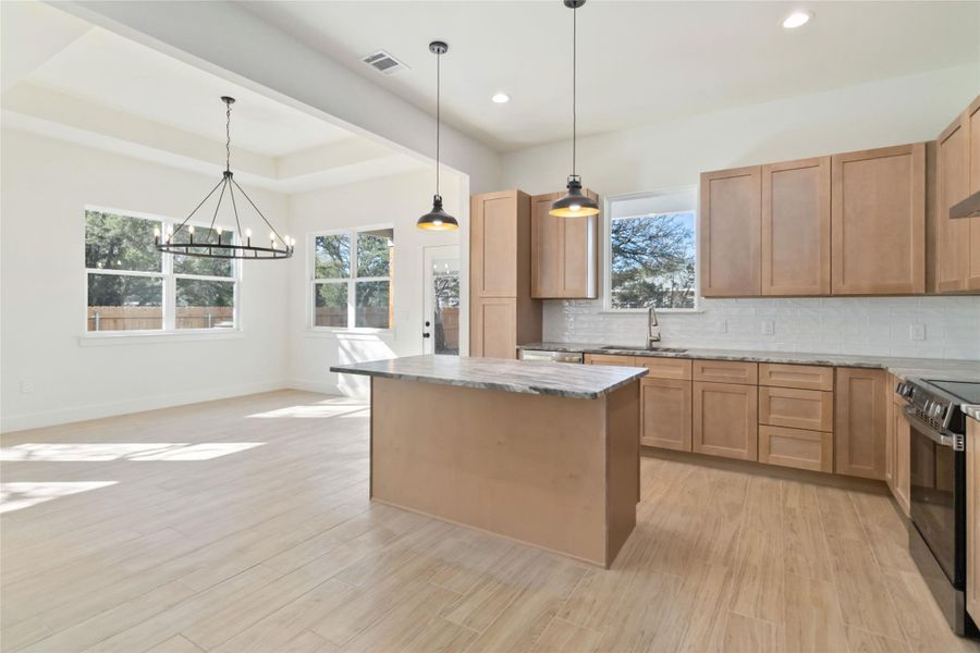 Kitchen with leathered granite island and view of dining area. Kitchen with leathered granite island and view of dining area.