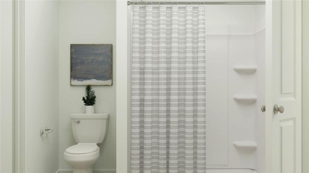 Bathroom featuring curtained shower and toilet