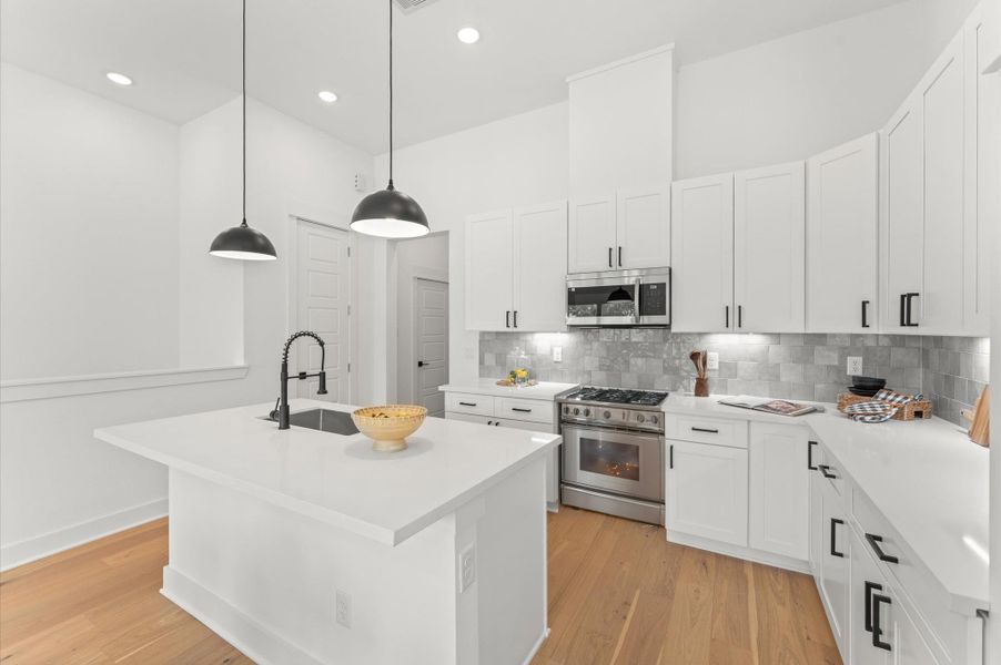 Striking kitchen island serves as the centerpiece of this open-concept space, offering both style and functionality. Topped with sleek quartz, the island includes bar seating for casual dining, ample storage with built-in cabinetry, and a spacious prep surface ideal for entertaining or everyday cooking. Pendant lighting overhead adds a touch of elegance, while the island’s placement encourages seamless flow between the kitchen, dining, and living areas. Striking kitchen island serves as the centerpiece of this open-concept space, offering both style and functionality. Topped with sleek quartz, the island includes bar seating for casual dining, ample storage with built-in cabinetry, and a spacious prep surface ideal for entertaining or everyday cooking. Pendant lighting overhead adds a touch of elegance, while the island’s placement encourages seamless flow between the kitchen, dining, and living areas.