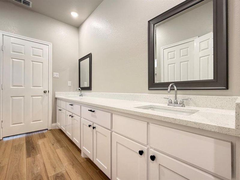 Full bathroom featuring double vanity, light wood-style floors, and recessed lighting Full bathroom featuring double vanity, light wood-style floors, and recessed lighting