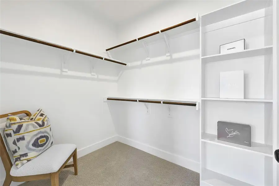 Spacious walk-in closet with built-in shelving and ample storage.