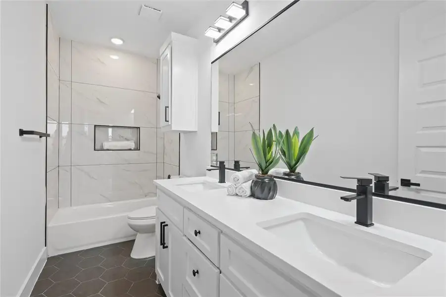 Bathroom featuring double vanity,  shower combination, and tile patterned floors