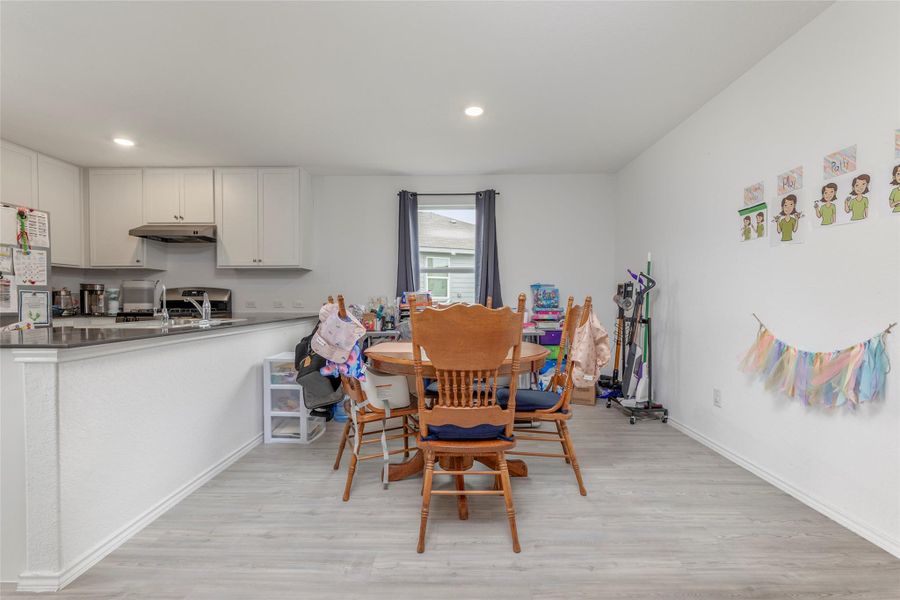 A welcoming dining area seamlessly transitions into a well-appointed kitchen, perfect for daily meals.