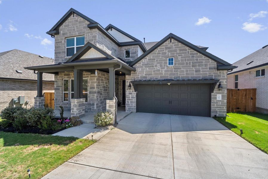 Constructed with natural stone, this multi-level facade features a welcoming covered front porch.
