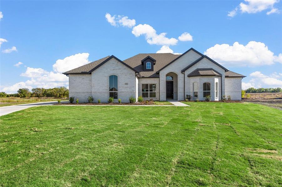 French provincial home featuring a front yard