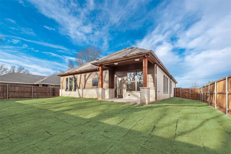 Back of house featuring brick siding, a patio area, and a fenced backyard