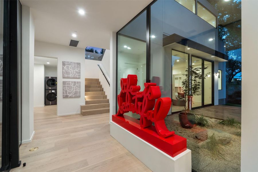 Community lobby featuring stairs, stacked washer / dryer, and recessed lighting Community lobby featuring stairs, stacked washer / dryer, and recessed lighting