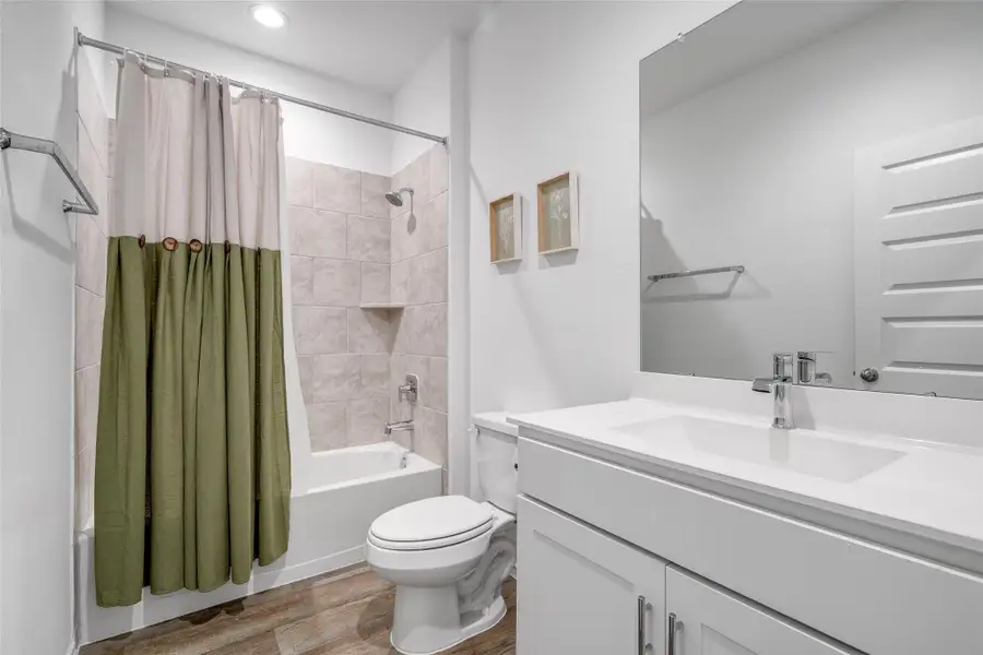 This bathroom offers a sleek tiled shower/tub combo, a classic white sink vanity, and a toilet, providing a clean and functional space. This bathroom offers a sleek tiled shower/tub combo, a classic white sink vanity, and a toilet, providing a clean and functional space.