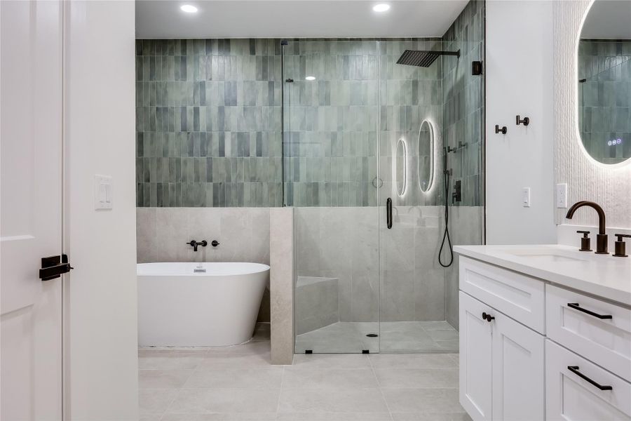 Full bathroom with a stall shower, tile walls, a freestanding bath, vanity, and recessed lighting Full bathroom with a stall shower, tile walls, a freestanding bath, vanity, and recessed lighting
