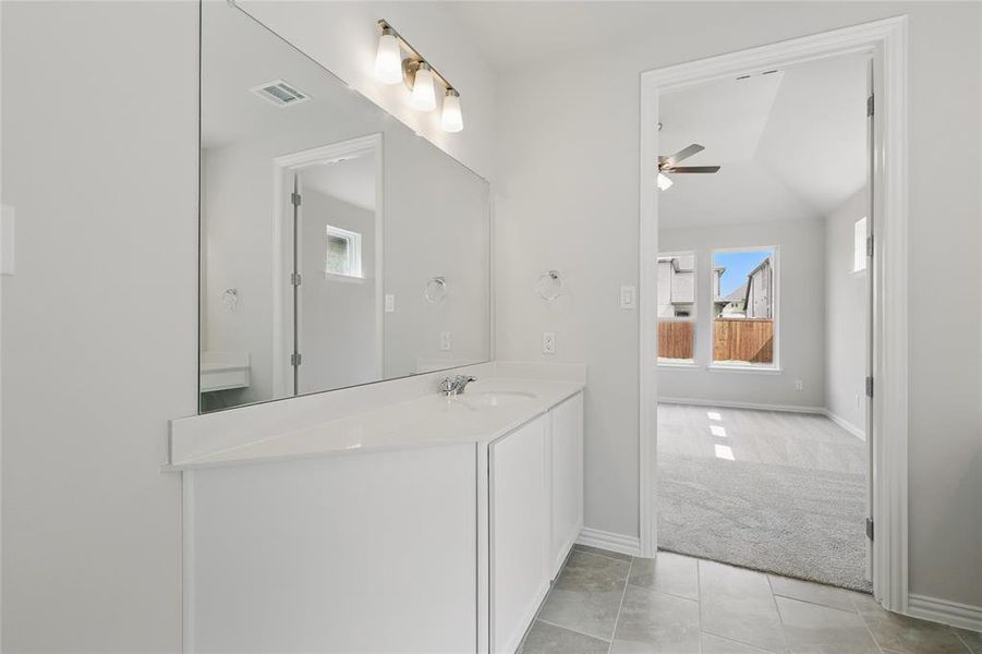 Bathroom featuring tile patterned flooring, ceiling fan, vanity, baseboards, and visible vents Bathroom featuring tile patterned flooring, ceiling fan, vanity, baseboards, and visible vents