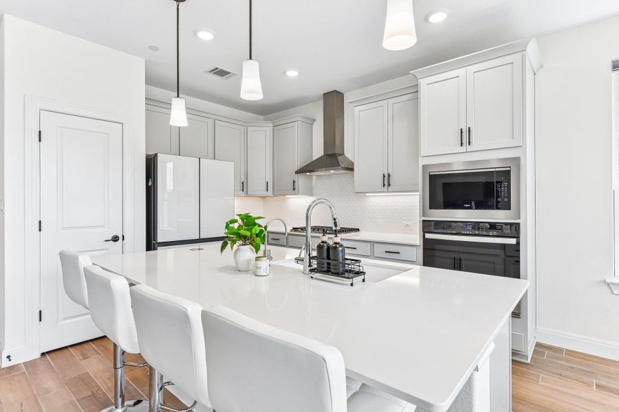 A streamlined kitchen island with a clean, light countertop anchors this cooking space.