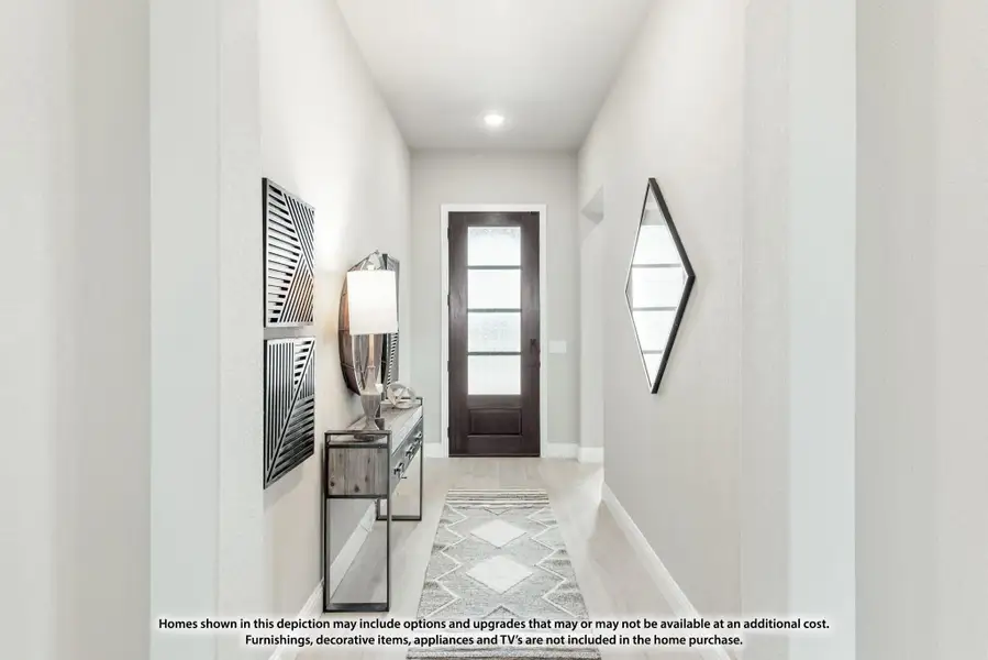 Narrow entryway with dark wood front door, console table, wall art, and light hardwood floors Narrow entryway with dark wood front door, console table, wall art, and light hardwood floors