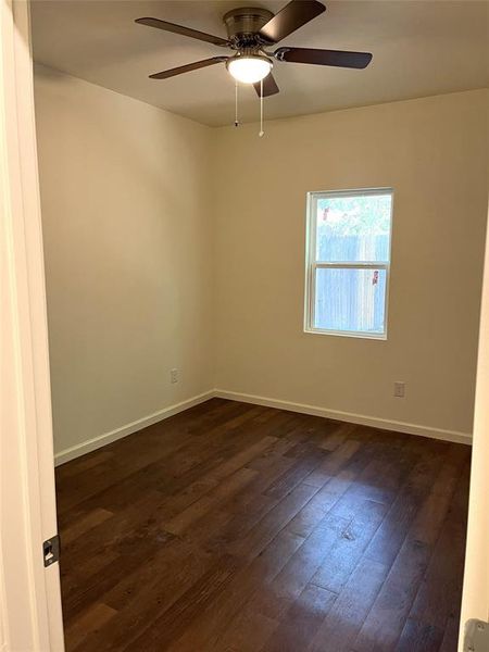 Room featuring wood-finish flooring, neutral wall tones, and a window for natural light