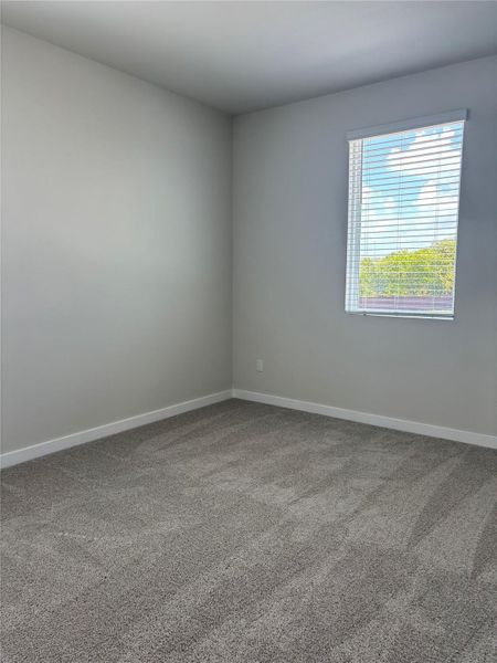 Carpeted empty room featuring baseboards