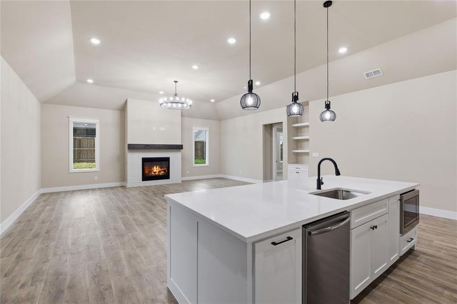 Open-concept living space featuring a central kitchen island with a built-in sink and stainless steel appliances Open-concept living space featuring a central kitchen island with a built-in sink and stainless steel appliances
