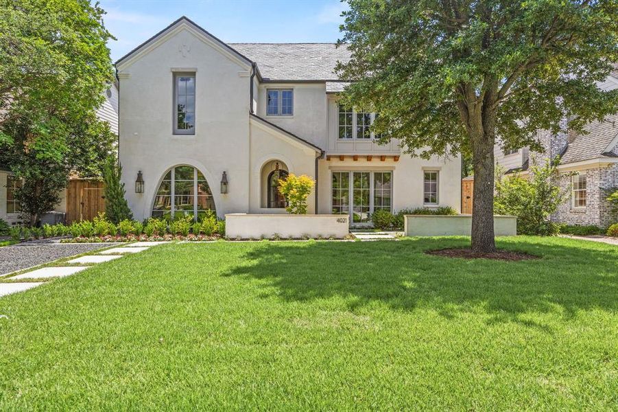 Contemporary exterior featuring white stucco, arched windows, a dark shingle roof, and a mature tree Contemporary exterior featuring white stucco, arched windows, a dark shingle roof, and a mature tree