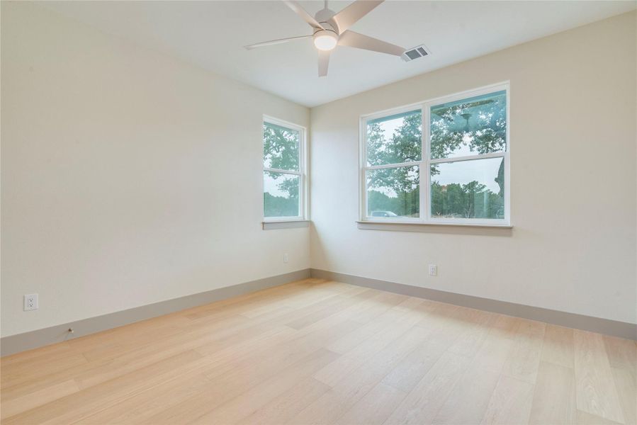 Unfurnished room with light wood-style flooring and a ceiling fan