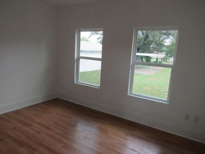 Empty room featuring wood finished floors and baseboards Empty room featuring wood finished floors and baseboards