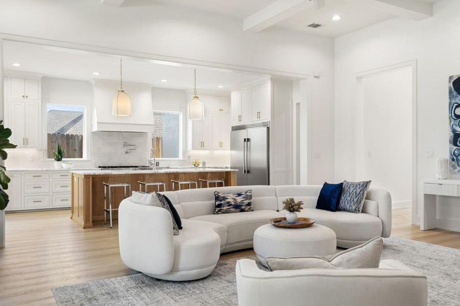 Living area featuring light wood-type flooring, beam ceiling, and recessed lighting