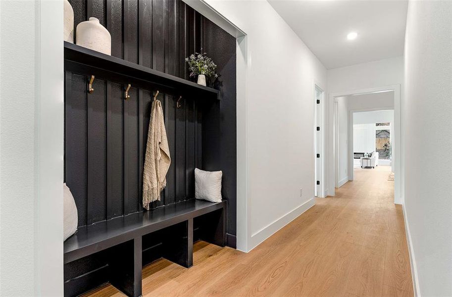 Mudroom featuring light wood-style floors and baseboards