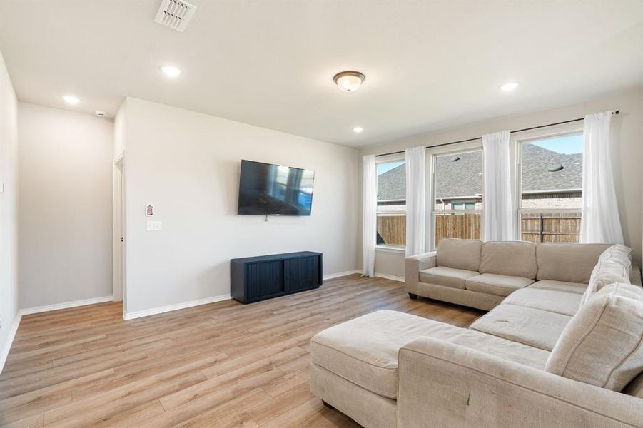 Living room featuring light wood-style floors and recessed lighting Living room featuring light wood-style floors and recessed lighting
