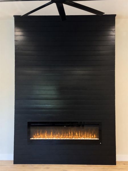 A modern floor-to-ceiling shiplap fireplace anchors the living space with clean architectural lines. A modern floor-to-ceiling shiplap fireplace anchors the living space with clean architectural lines.