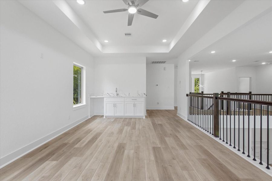 The second floor offers an ample game room featuring tray ceilings, luxury vinyl flooring, and a wet bar ready for a beverage fridge. The second floor offers an ample game room featuring tray ceilings, luxury vinyl flooring, and a wet bar ready for a beverage fridge.