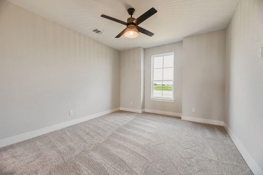Empty room featuring light colored carpet and ceiling fan