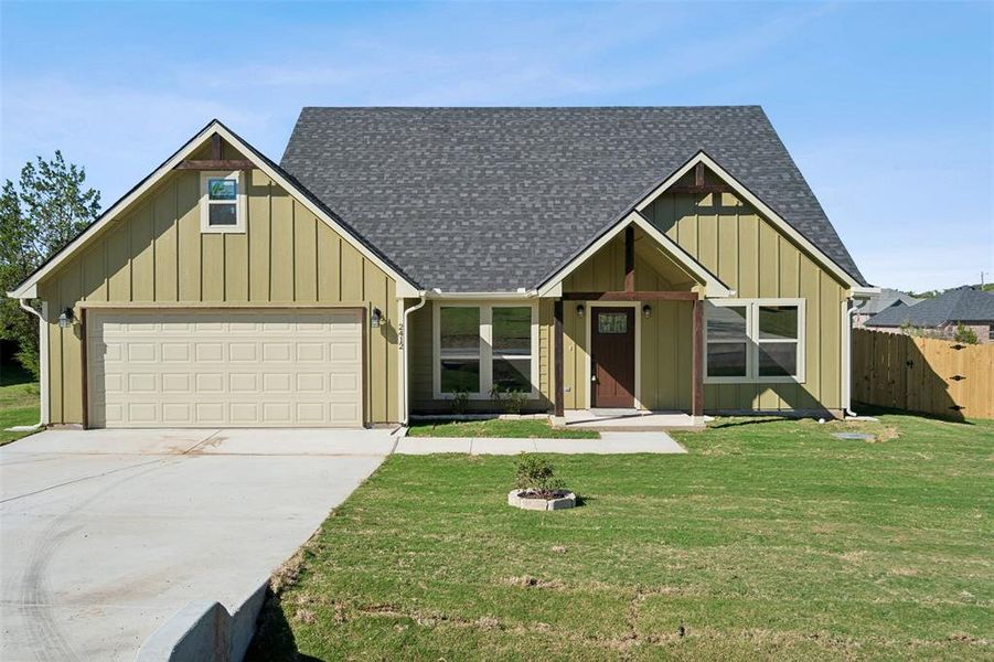 View of front of home with a front lawn and a garage