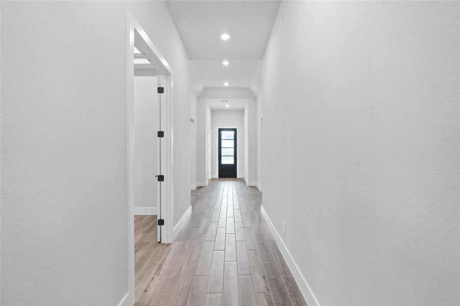This long hallway description emphasizes the home's bright, modern design and architectural depth. Please note the game room entrance on the left.