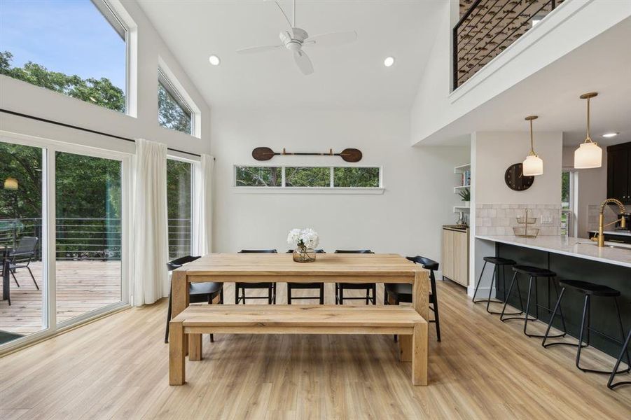 Dining area with a high ceiling, sink, and light hardwood / wood-style floors