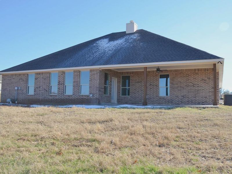 Rear view of house featuring a yard