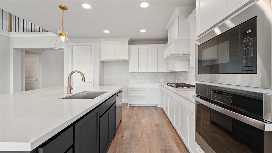 Kitchen with white cabinets, stainless steel appliances, and sink